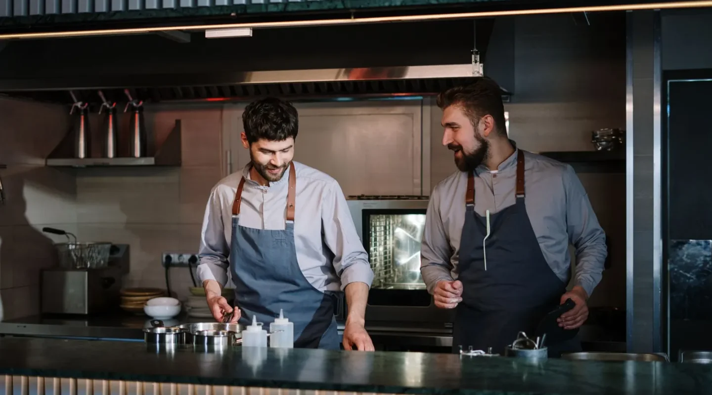 Dois cozinheiros trabalhando em uma cozinha aberta de restaurante