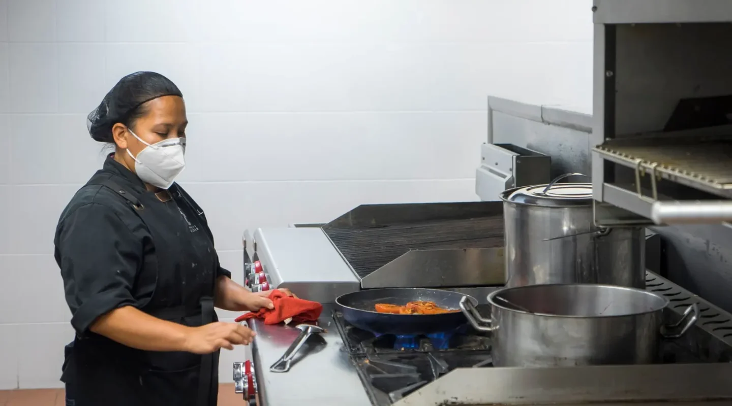 Cozinheira trabalhando em uma cozinha profissional