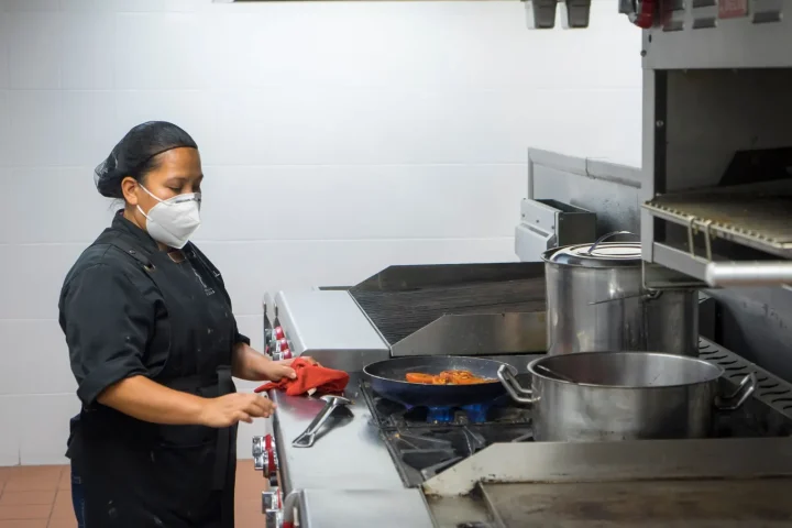 Cozinheira trabalhando em uma cozinha profissional