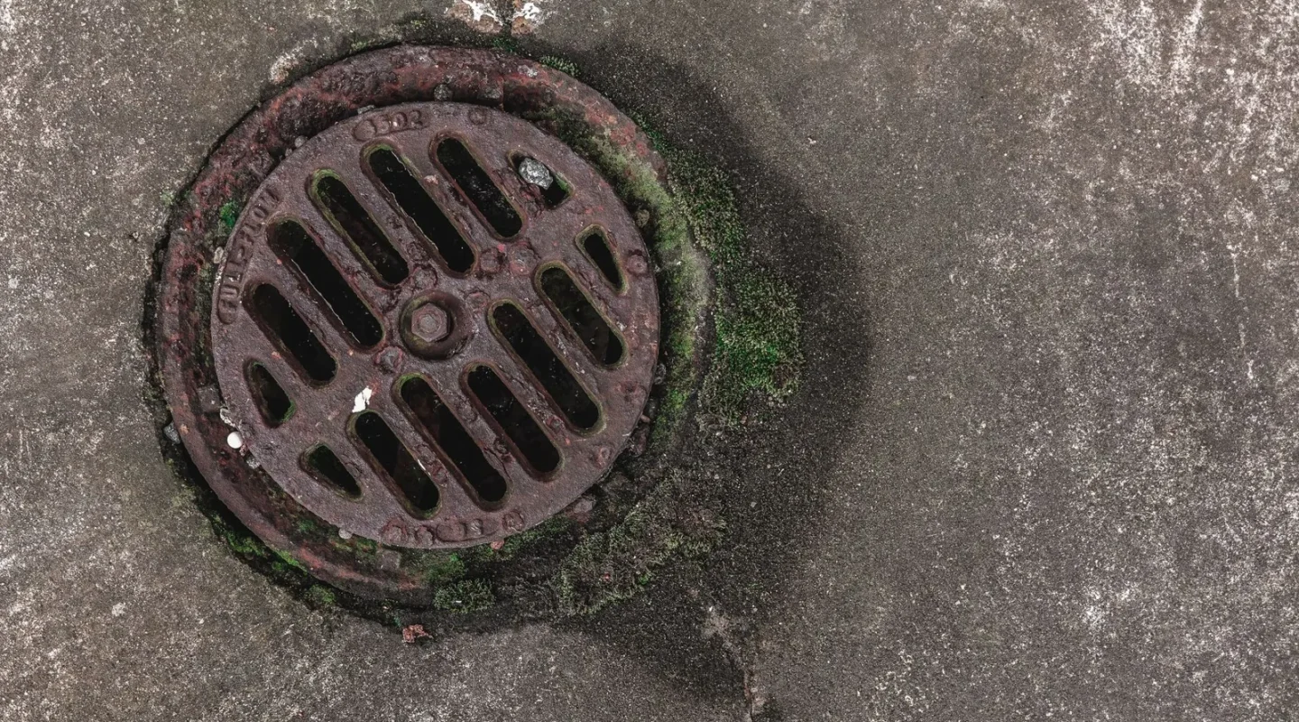 Ralo de ferro com grelha circular em piso de concreto
