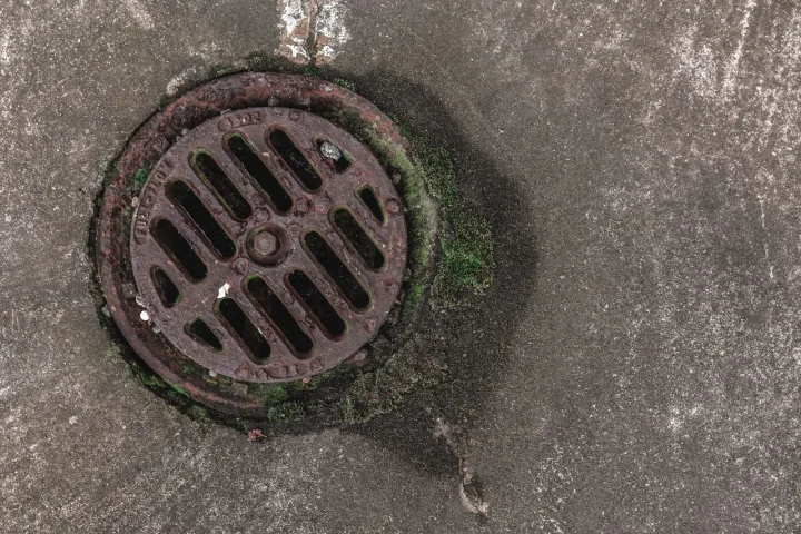 Ralo de ferro com grelha circular em piso de concreto
